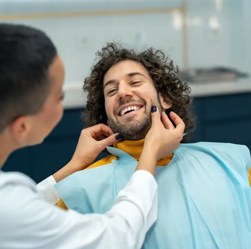 A smiling young man in the dental chair