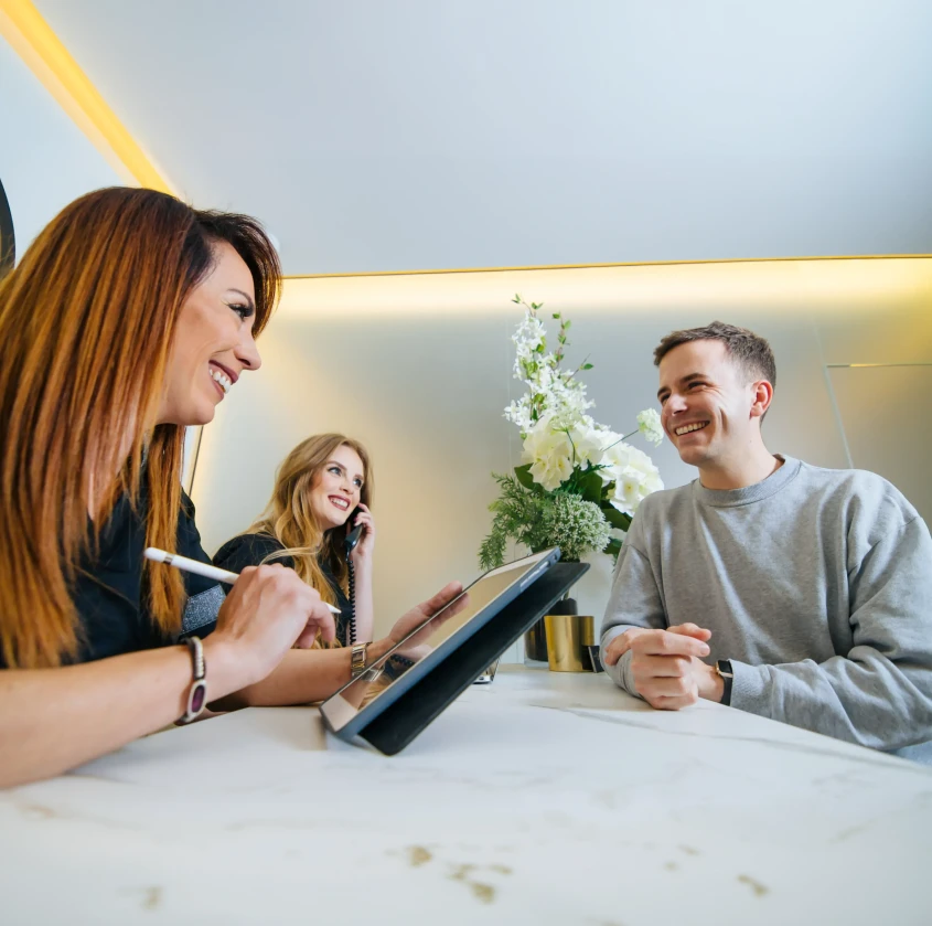 A smiling patient being welcomed at the front desk